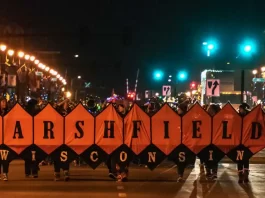 Holiday parade image with band holding "Marshfield" banner