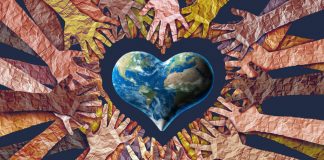 Human hands surrounding heart shaped earth