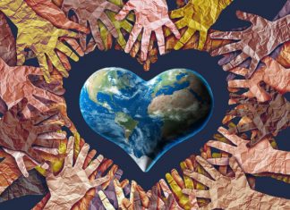 Human hands surrounding heart shaped earth