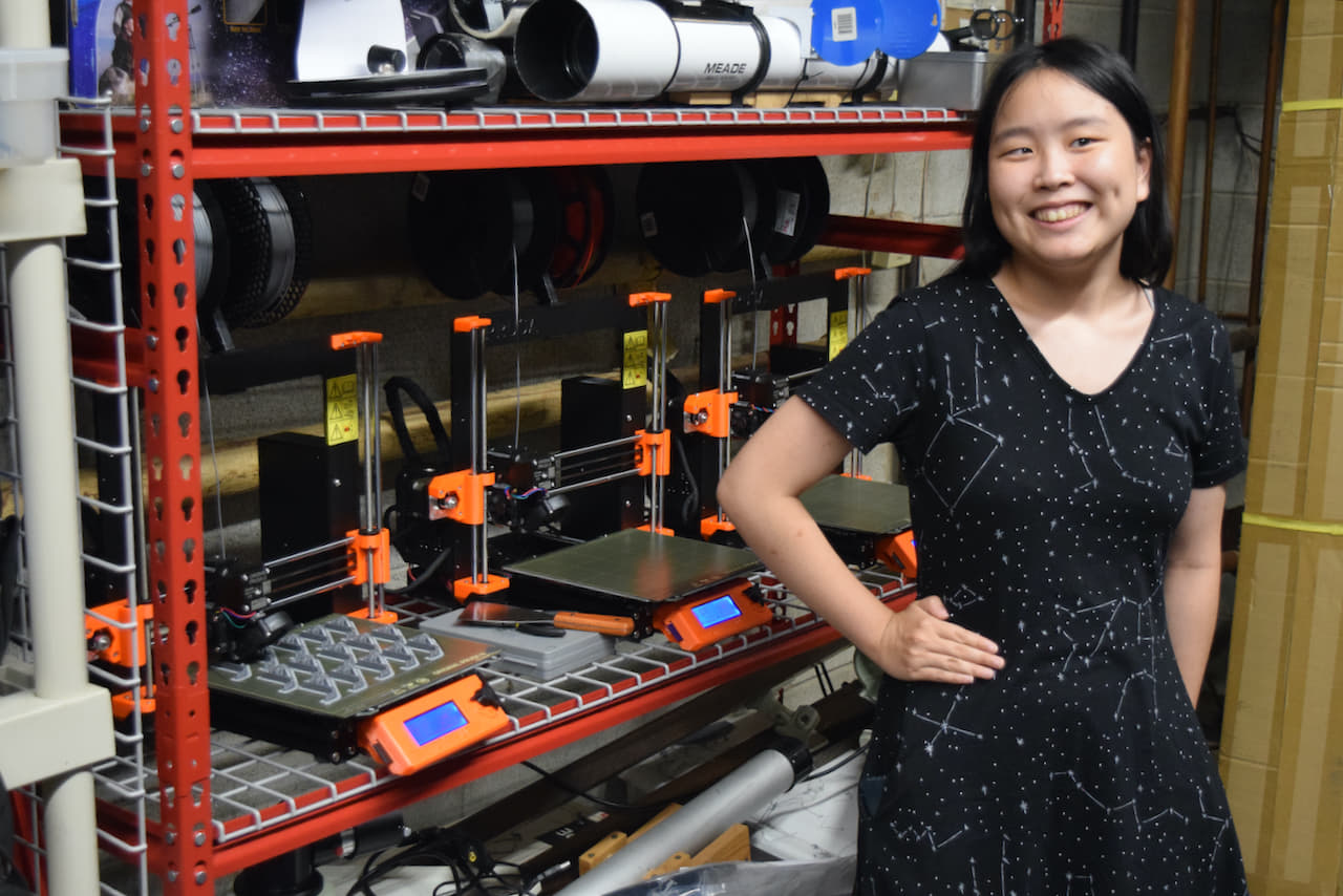 woman standing proudly in front of 3d printers