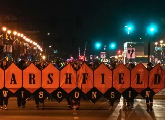 Holiday parade image with band holding "Marshfield" banner